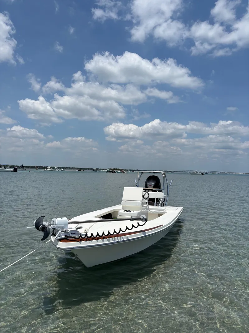 Slide: The Image of 2024 Islamorada Boatworks Morada 18 in shallow water under a partly cloudy sky. - 5