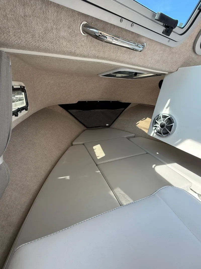 Slide: The Image of Interior of 2025 Parker 2120 Sport Cabin boat, featuring cushioned seating and speaker. - 11