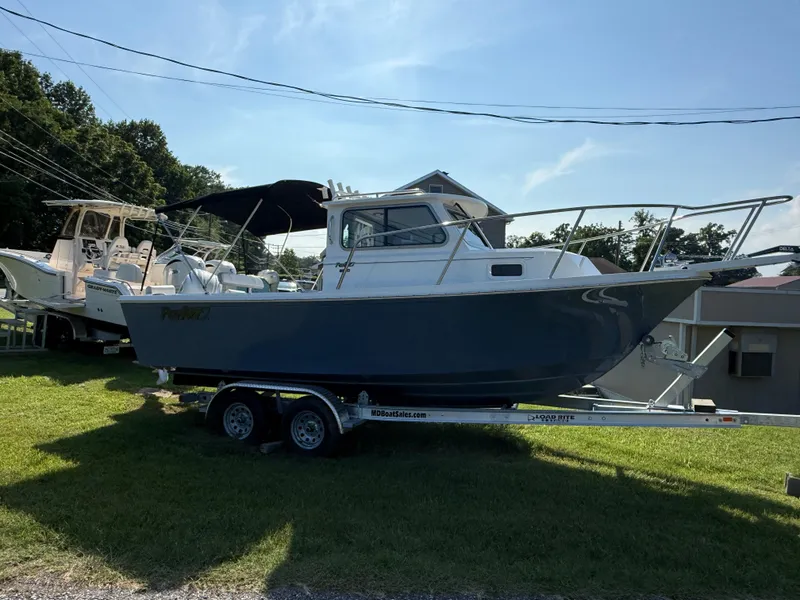 Slide: The Image of 2025 Parker 2120 Sport Cabin boat on trailer, displayed outdoors. - 3