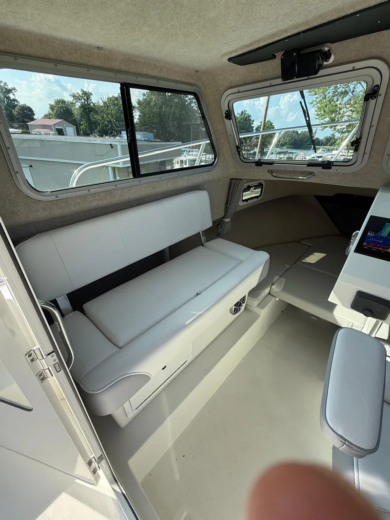 Slide: The Image of Interior of 2025 Parker 2120 Sport Cabin boat with seating and windows. - 9