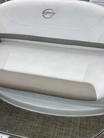 Slide: The Image of 2015 Crownline 264 CR boat seating with logo, featuring beige and white upholstery. - 10