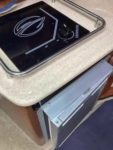 Slide: The Image of 2015 Crownline 264 CR boat interior with stove and refrigerator. - 16