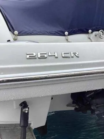 Slide: The Image of 2015 Crownline 264 CR boat with blue cover on water. - 18
