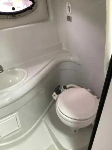 Slide: The Image of 2015 Crownline 264 CR boat bathroom with compact toilet and sink. - 21