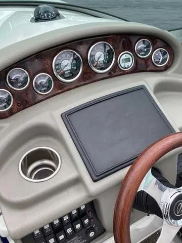 Slide: The Image of 2015 Crownline 264 CR boat dashboard with gauges, wood-trimmed steering wheel, and control panel. - 22