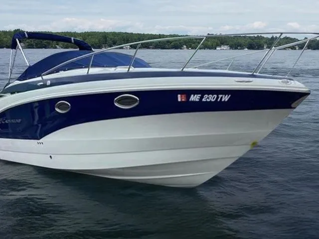 Slide: The Image of 2015 Crownline 264 CR boat on water, blue and white design, side view. - 3