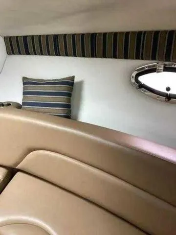Slide: The Image of 2015 Crownline 264 CR cabin interior with striped pillow and porthole window. - 7