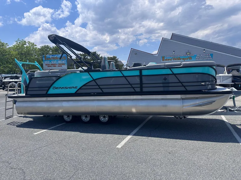 Slide: The Image of 2025 Berkshire 23RFX STS 3.0 pontoon boat in a parking lot under a cloudy sky. - 0