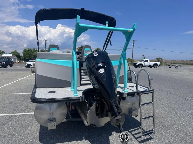 Slide: The Image of 2025 Berkshire 23RFX STS 3.0 pontoon boat with outboard motor in parking lot. - 3