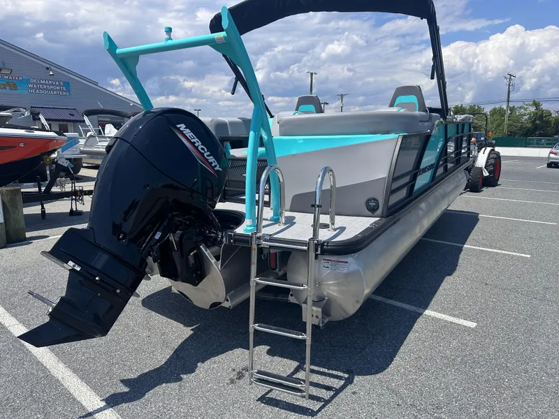 Slide: The Image of 2025 Berkshire 23RFX STS 3.0 pontoon boat with Mercury outboard motor in parking lot. - 4