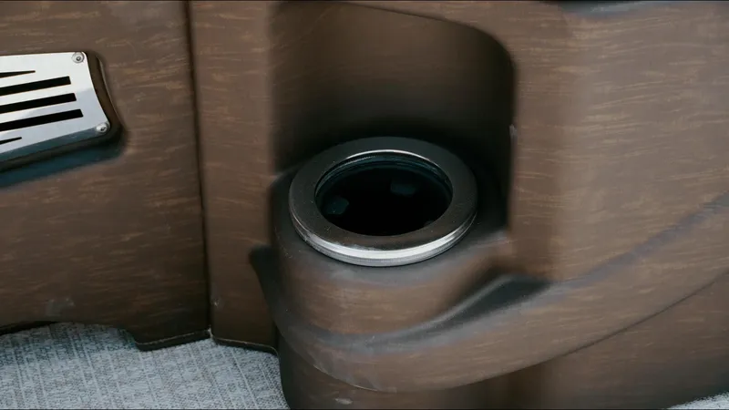 Slide: The Image of Cup holder in 2025 Tahoe Pontoon LTZ Cruise Rear Bench, brown interior detail. - 13