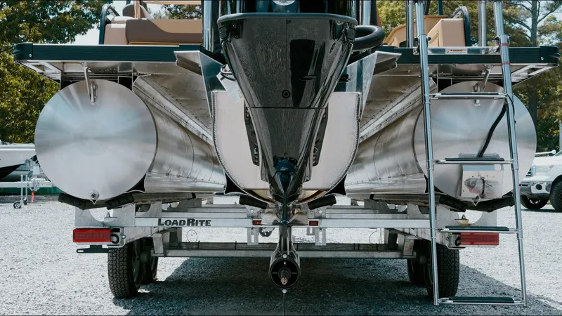 Slide: The Image of 2025 Tahoe Pontoon LTZ Cruise Rear Bench on trailer, showcasing pontoons and ladder. - 24