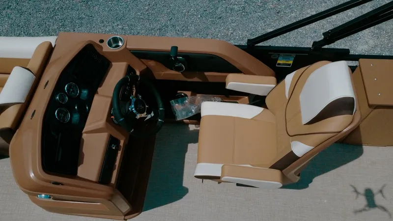 Slide: The Image of 2025 Tahoe Pontoon LTZ Cruise Rear Bench interior with tan seating and steering console. - 5