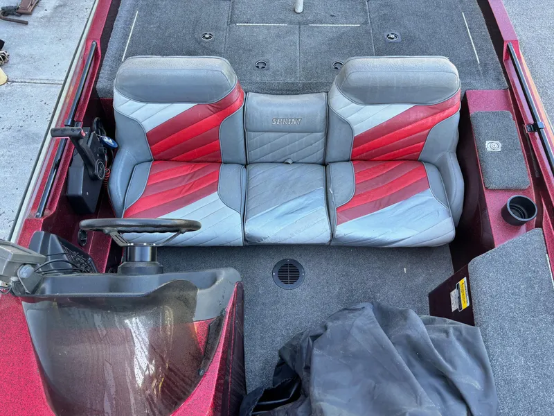 Slide: The Image of Red and gray interior of a 1995 Sprint 277 boat with steering wheel and seating. - 6