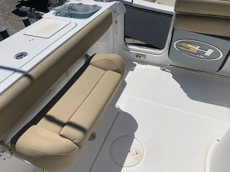 Slide: The Image of 2018 Sea Hunt Gamefish 27 boat interior with beige seating and storage compartments. - 10