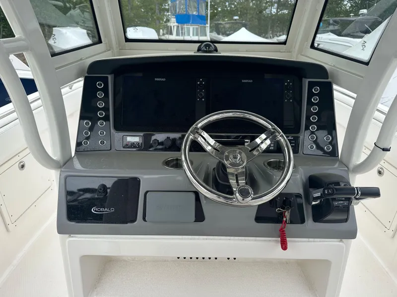 Slide: The Image of 2021 Robalo R272 Center Console boat dashboard with steering wheel and control panel. - 10