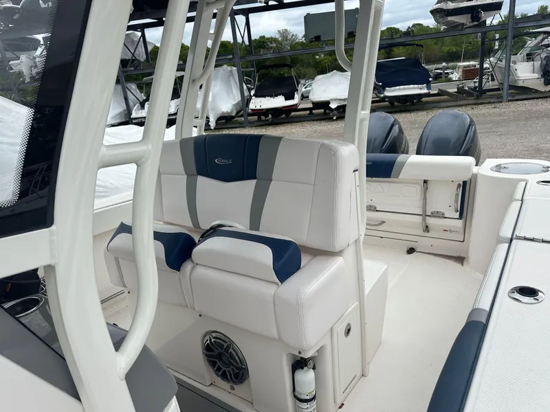 Slide: The Image of 2021 Robalo R272 Center Console boat interior with cushioned seating and dual engines. - 11