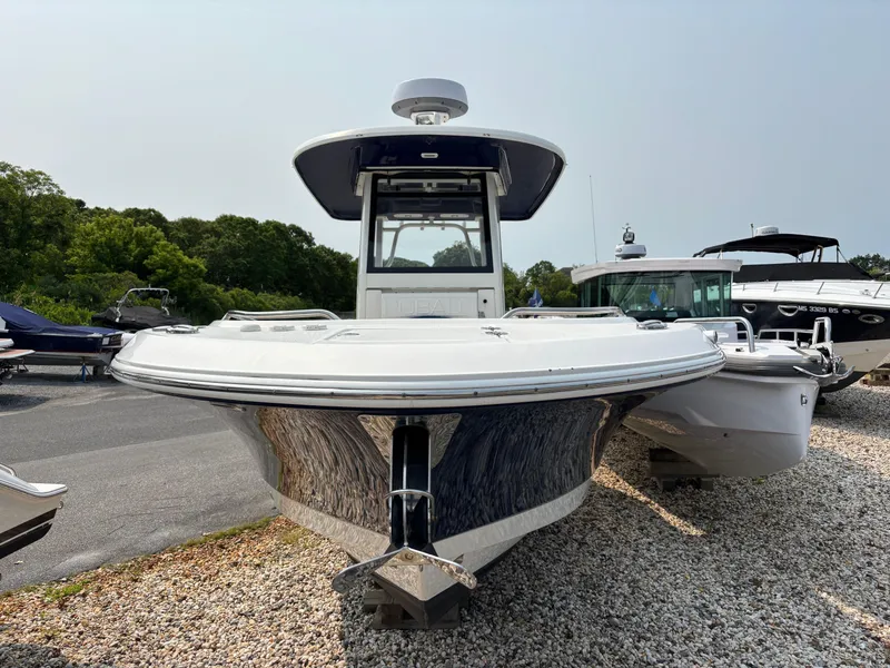Slide: The Image of 2021 Robalo R272 Center Console boat on gravel, front view. - 2