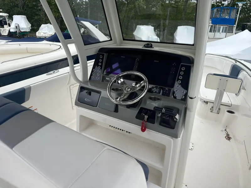 Slide: The Image of 2021 Robalo R272 Center Console boat interior with steering wheel and control panel. - 9