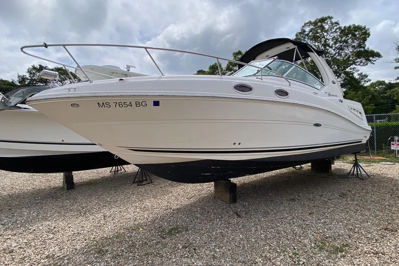 Slide: The Image of 2007 Sea Ray 260 Sundancer docked at marina, with large boat in background. - 0