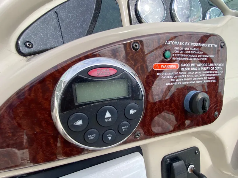 Slide: The Image of 2007 Sea Ray 260 Sundancer boat interior with seating and helm, docked outdoors. - 14