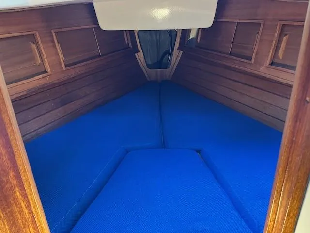 Slide: The Image of 1978 Bristol 29.9 sailboat interior with blue cushions and wooden paneling. - 11