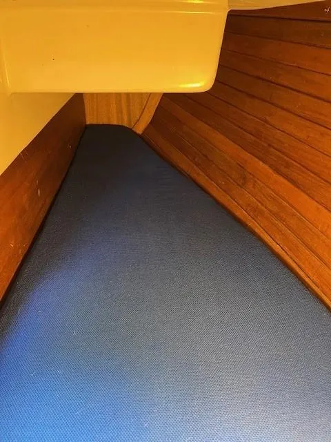 Slide: The Image of 1978 Bristol 29.9 sailboat interior with blue cushion and wooden paneling. - 12