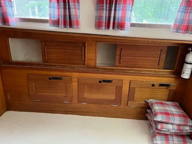 Slide: The Image of Interior of a 1978 Bristol 29.9 boat with wooden cabinets and plaid curtains. - 13
