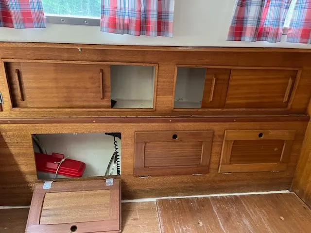 Slide: The Image of 1978 Bristol 29.9 interior with wooden cabinets and plaid curtains. - 14