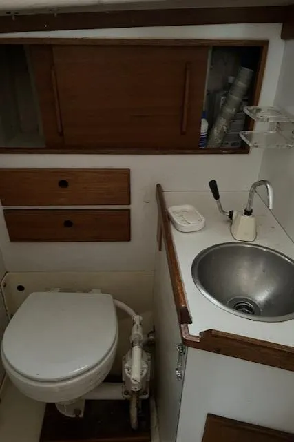 Slide: The Image of 1978 Bristol 29.9 boat bathroom with sink, toilet, and wooden cabinets. - 15