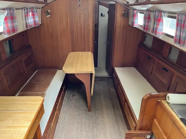 Slide: The Image of Interior of a 1978 Bristol 29.9 sailboat with wooden furnishings and plaid curtains. - 7