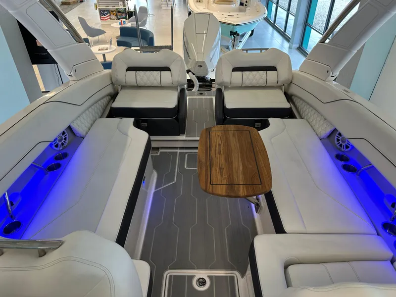 Slide: The Image of Luxurious 2025 Regal LX6 boat interior with white seating, blue LED lighting, and wooden table. - 3