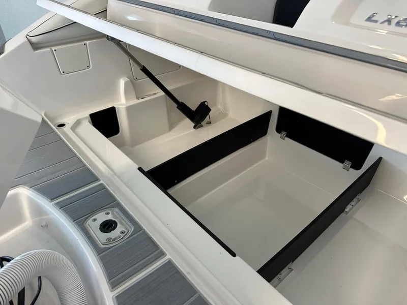 Slide: The Image of 2025 Regal LX6 boat storage compartment with open lid, showcasing spacious interior design. - 35