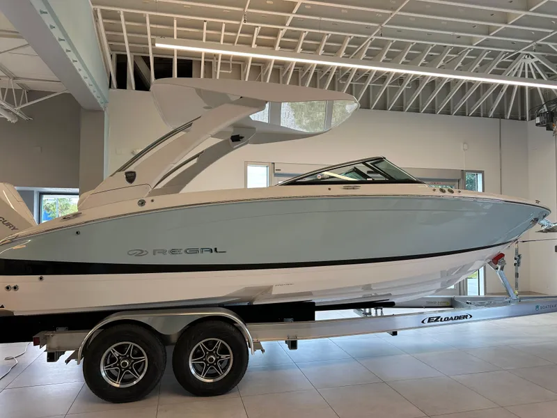Slide: The Image of 2025 Regal LX6 boat on trailer in showroom, showcasing sleek design and modern features. - 4