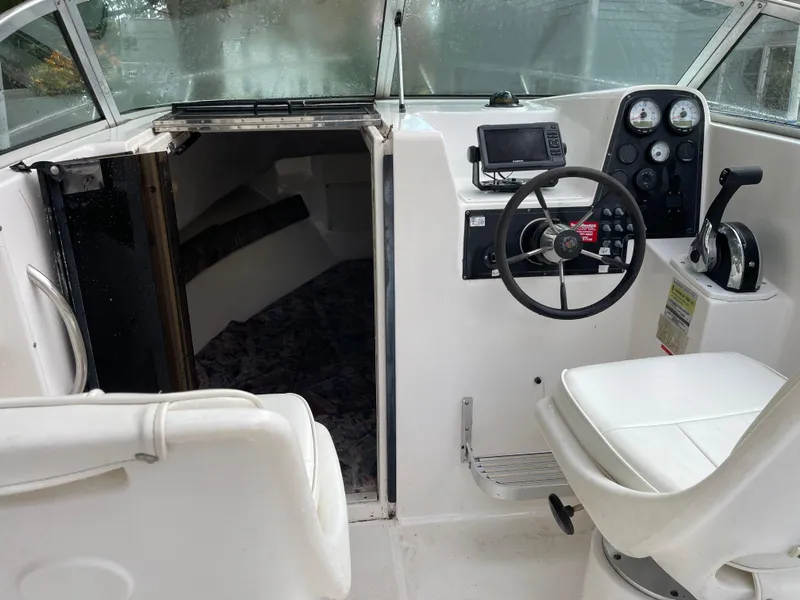 Slide: The Image of 1998 Wellcraft 210 Coastal boat interior with steering wheel and cabin entrance. - 10