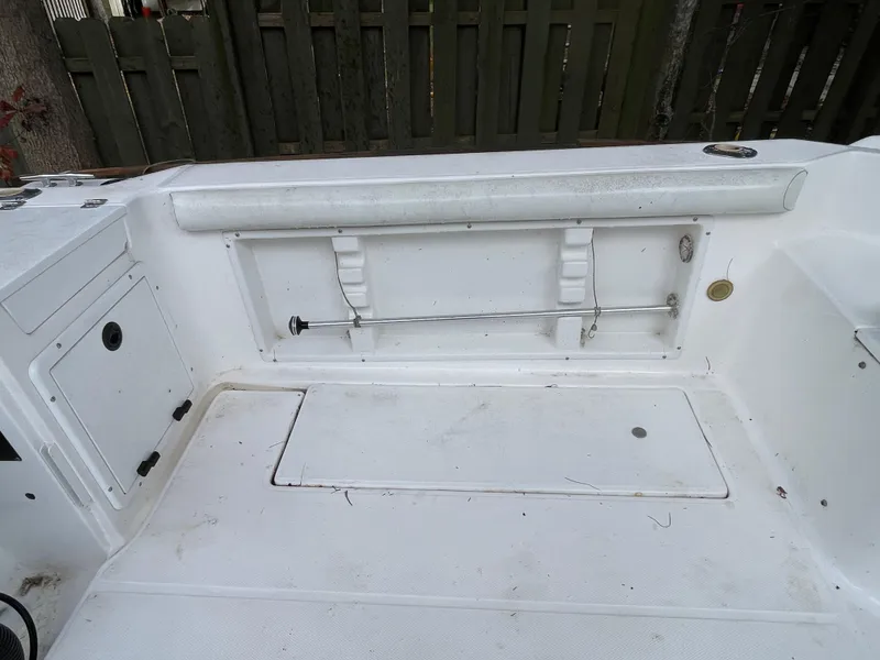 Slide: The Image of 1998 Wellcraft 210 Coastal boat interior, featuring white seating and storage compartments. - 11