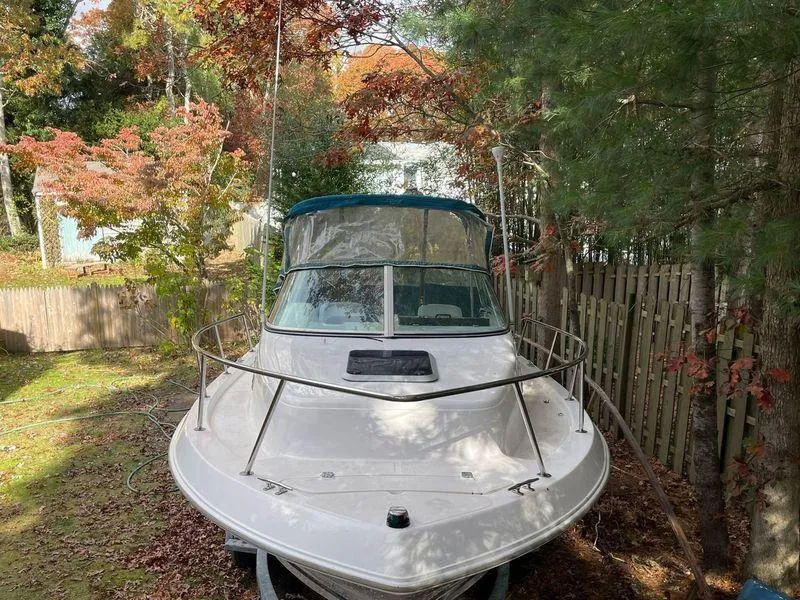 Slide: The Image of 1998 Wellcraft 210 Coastal boat parked in a leafy yard. - 7