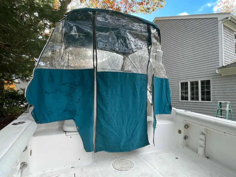 Slide: The Image of 1998 Wellcraft 210 Coastal boat with blue canopy, docked near a house. - 8