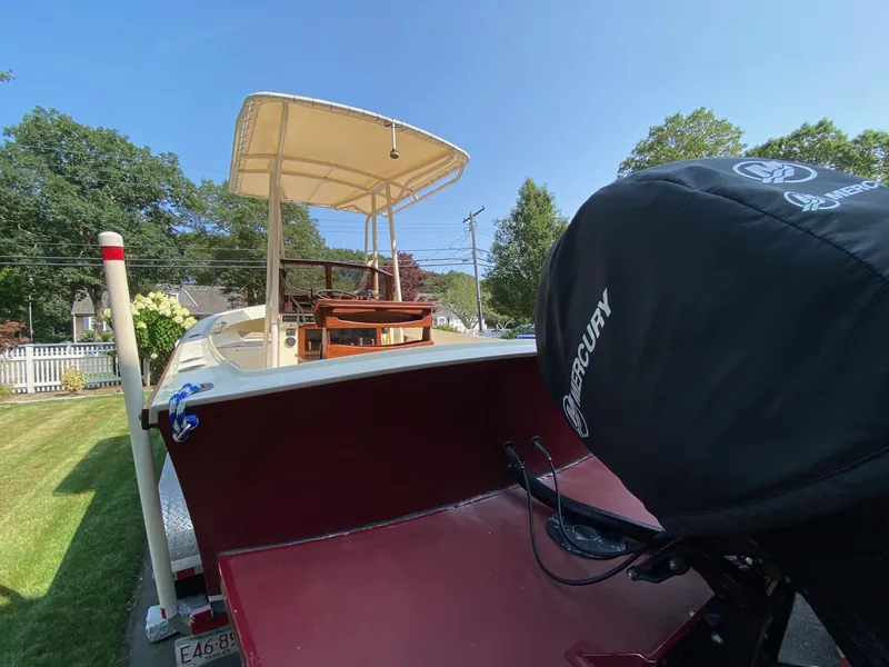 Slide: The Image of 2005 Roth Bilt 21 Classic boat with Mercury engine, parked on a grassy lawn. - 5