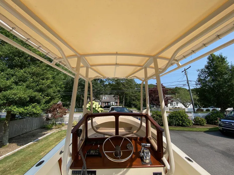 Slide: The Image of 2005 Roth Bilt 21 Classic boat with canopy, parked in a residential driveway. - 8