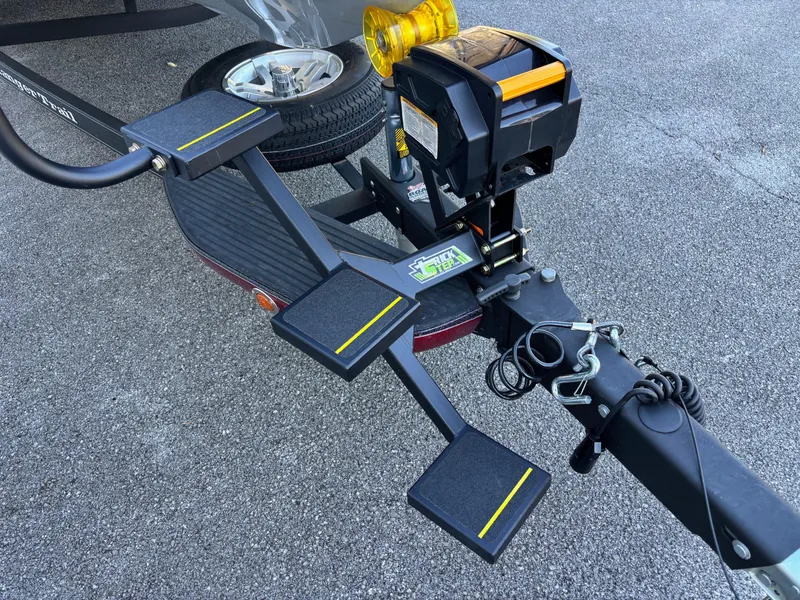 Slide: The Image of Trailer hitch and steps of a 2020 Ranger Z185 boat on asphalt. - 2