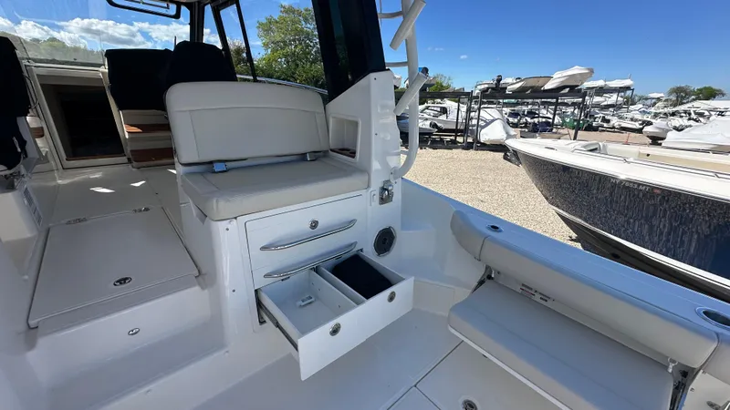 Slide: The Image of 2025 Boston Whaler 405 Conquest interior with seating and storage drawers, docked at marina. - 15