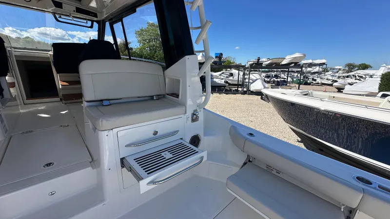 Slide: The Image of 2025 Boston Whaler 405 Conquest interior, featuring seating and storage, docked under clear blue skies. - 16