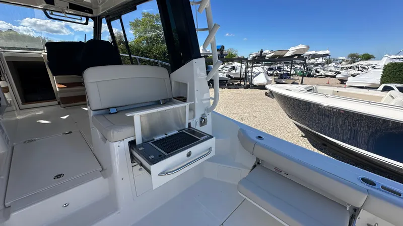 Slide: The Image of 2025 Boston Whaler 405 Conquest interior with seating and storage, docked at a marina. - 17