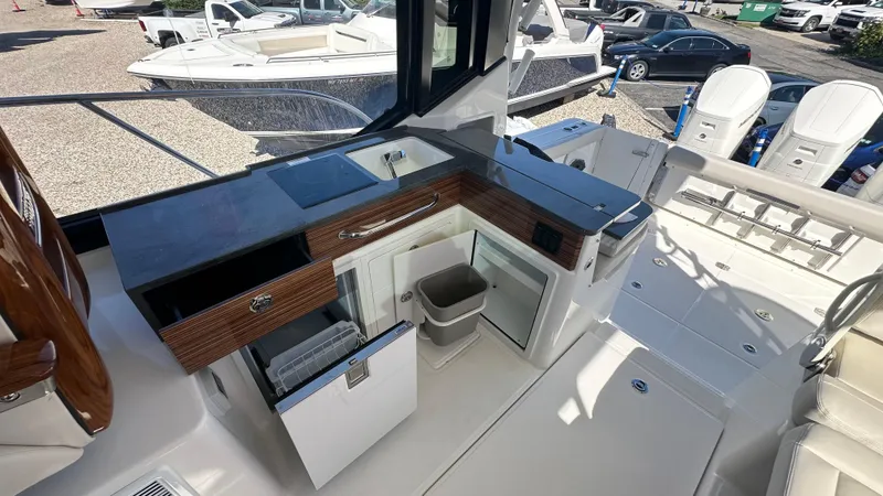 Slide: The Image of 2025 Boston Whaler 405 Conquest boat interior with kitchenette and seating area. - 24