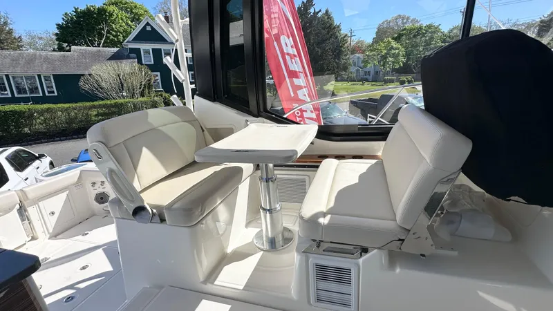 Slide: The Image of 2025 Boston Whaler 405 Conquest interior seating area with table, showcasing luxury design. - 25