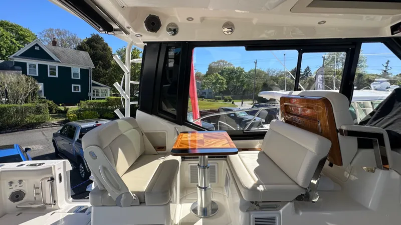 Slide: The Image of Interior of 2025 Boston Whaler 405 Conquest, featuring luxurious seating and a wooden table. - 26