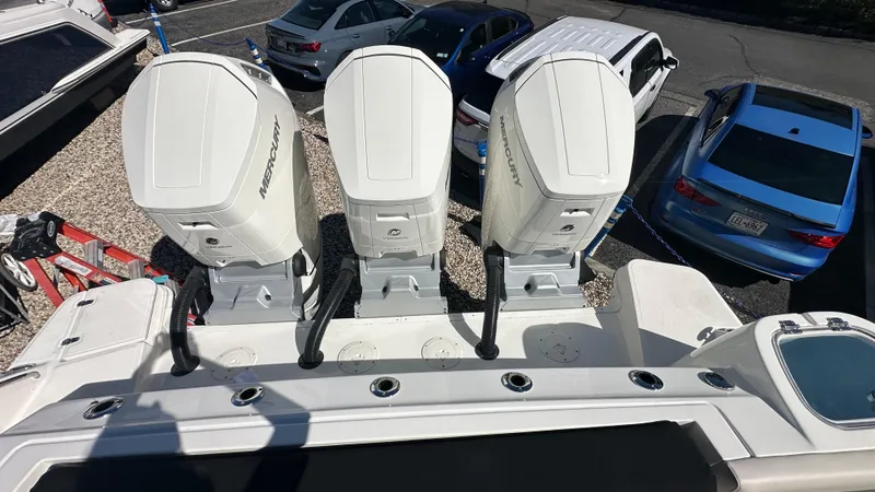 Slide: The Image of 2025 Boston Whaler 405 Conquest with triple outboard engines in a parking lot. - 3