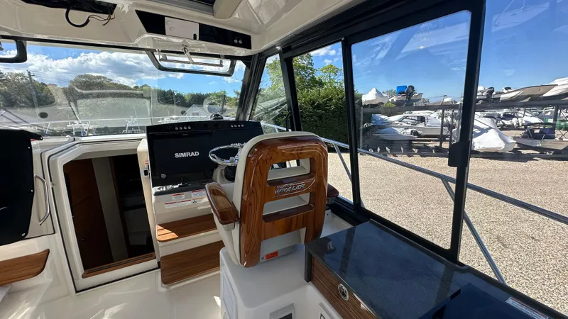 Slide: The Image of Interior of 2025 Boston Whaler 405 Conquest boat with modern helm and large windows. - 32