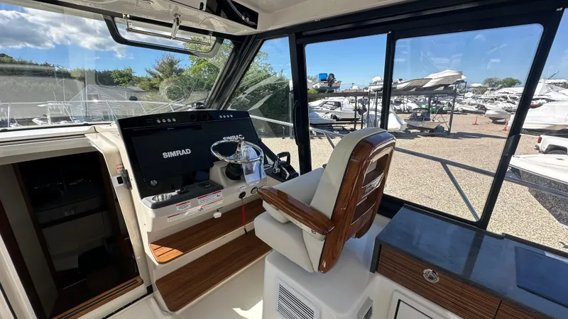 Slide: The Image of Helm of 2025 Boston Whaler 405 Conquest with modern controls and panoramic windows. - 33